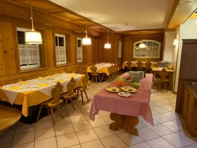 a dining room with tables and chairs in a restaurant at Dolomites Hotel La Meridiana in Moena