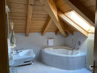 a bathroom with a large tub and a sink at Dolomites Hotel La Meridiana in Moena