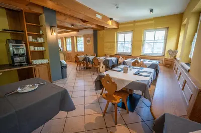 a restaurant with tables and chairs in a room at Dolomites Hotel La Meridiana in Moena