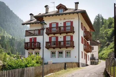 a building with balconies on the side of a road at Dolomites Hotel La Meridiana in Moena