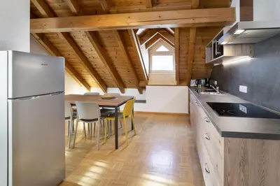 a kitchen with a table and a refrigerator at Apartments Gasser in Rasun di Sopra