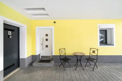a table and chairs in front of a yellow wall at Apartments Gasser in Rasun di Sopra