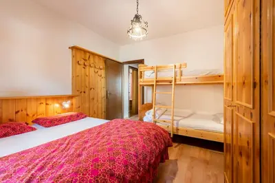 a bedroom with a bed and a bunk bed at Delizioso appartamento trilocale a Moena in Moena