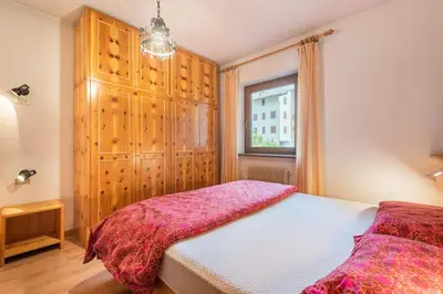 a bedroom with a bed and a window at Delizioso appartamento trilocale a Moena in Moena