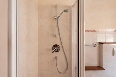 a shower with a shower head in a bathroom at Delizioso appartamento trilocale a Moena in Moena
