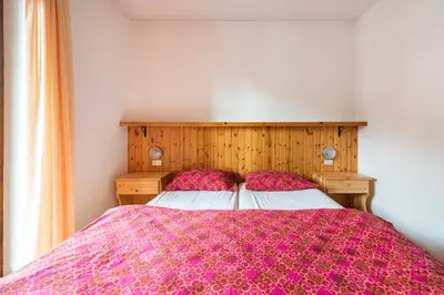 a bedroom with a large bed with a purple blanket at Delizioso appartamento trilocale a Moena in Moena