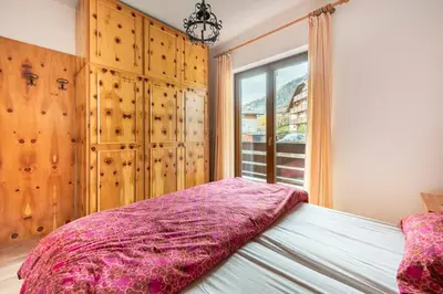 a bedroom with a bed and a window at Delizioso appartamento trilocale a Moena in Moena