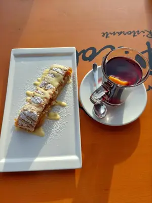 a white plate with a piece of food on a table at La tana del Lupo in Falcade