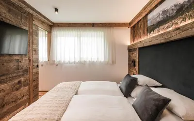 a bedroom with a large bed and a television at Biohof Untergröber in Braies