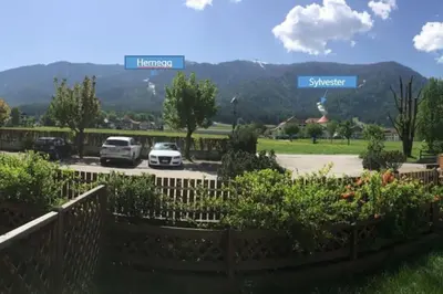 two cars parked in a parking lot with mountains in the background at Sylvester Apartment in Riscone