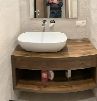 a white sink on a wooden counter in a bathroom at Sylvester Apartment in Riscone