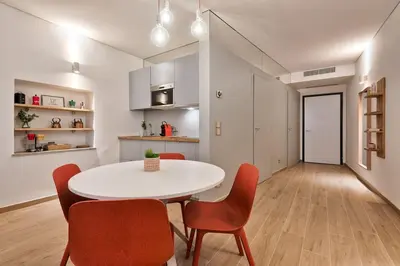 a kitchen and dining room with a white table and chairs at Lauben Flat Bolzano in Bolzano
