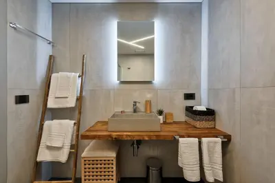 a bathroom with a sink and a mirror and towels at Lauben Flat Bolzano in Bolzano