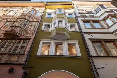 a yellow building with white windows on a street at Lauben Flat Bolzano in Bolzano
