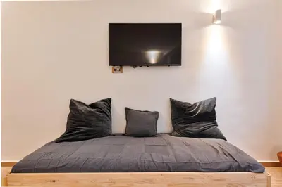 a bedroom with a bed with a flat screen tv on the wall at Lauben Flat Bolzano in Bolzano