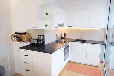 a kitchen with white cabinets and a black counter top at Apartment Lauben - Alpstay in Merano