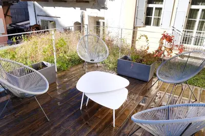 a deck with three chairs and a table and a table and chairs at Apartment Lauben - Alpstay in Merano
