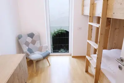 a living room with a chair and a bunk bed at Apartment Lauben - Alpstay in Merano