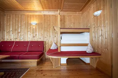 a room with a red couch and a bunk bed at Apartment Carolina in Ortisei