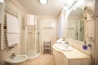 a bathroom with a sink and a shower and a mirror at Apartment Carolina in Ortisei