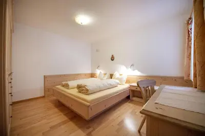 a bedroom with a bed and a desk in a room at Apartment Carolina in Ortisei