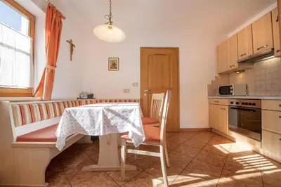 a kitchen with a table and a table and a chair at Apartment Carolina in Ortisei