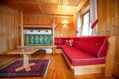 a living room with a red couch and a stove at Apartment Carolina in Ortisei