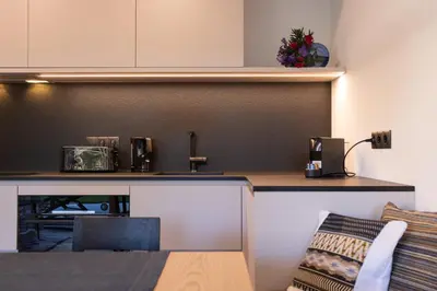 a kitchen with a counter top and a table at Apartment Ando in Brunico