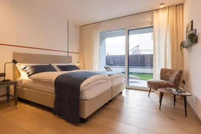 a bedroom with a bed and a large window at Apartment Ando in Brunico