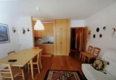 a kitchen and dining room with a table and chairs at La casa di Antonello Chiara Alessandro e Ginevra in Malga Ciapela