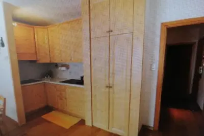 a kitchen with wooden cabinets in a room at La casa di Antonello Chiara Alessandro e Ginevra in Malga Ciapela