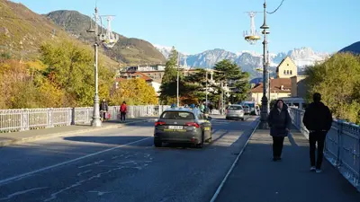 a man and a woman walking down a street with a car at Haus Gugler in Bolzano