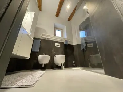 a bathroom with two urinals and two sinks in it at Haus Gugler in Bolzano