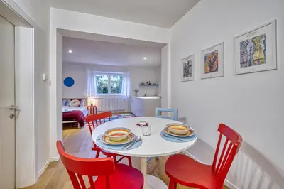 a dining room with a white table and red chairs at HOMESTWENTY3 - Home one in Caldaro