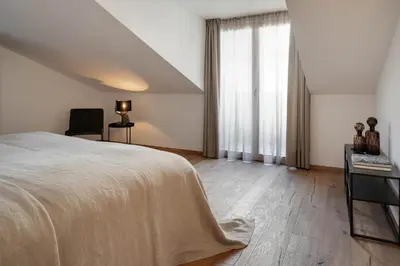a bedroom with a bed and a desk and a window at Attica 54 Apartments Merano in Merano