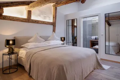 a bedroom with a large bed with white sheets and pillows at Attica 54 Apartments Merano in Merano