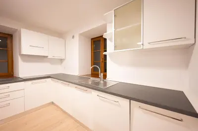 a white kitchen with white cabinets and a sink at Cesa Meida 2A in Pozza di Fassa