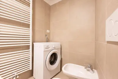 a bathroom with a washing machine and a sink at Cesa Meida 2B in Pozza di Fassa