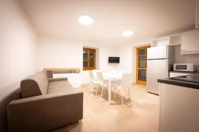a living room and kitchen with a couch and a table at Cesa Meida 2B in Pozza di Fassa