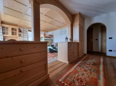 a kitchen with an archway and a living room at Appartamento ai larici, rustico ed elegante in Varena