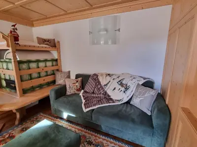 a living room with a couch and a bunk bed at Appartamento ai larici, rustico ed elegante in Varena