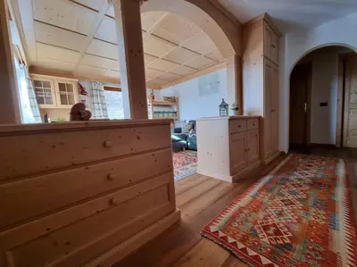 a large room with a kitchen and a living room at Appartamento ai larici, rustico ed elegante in Varena