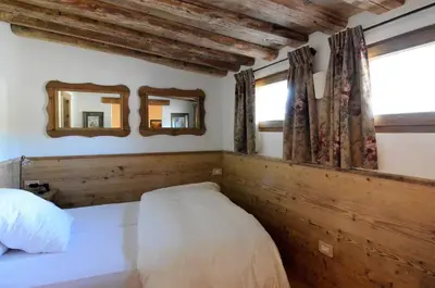 a bedroom with a bed and two mirrors on the wall at Charming Studio in Chiave