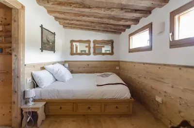 a bedroom with a bed and two windows at Charming Studio in Chiave