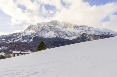 a snow covered mountain in front of a ski slope at Charming Studio in Chiave