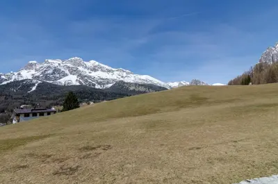 a green field with snow capped mountains in the background at Charming Studio in Chiave