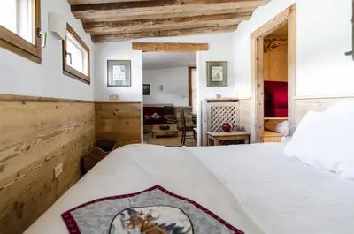 a bedroom with a white bed and wooden walls at Charming Studio in Chiave