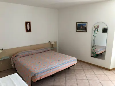 a bedroom with a bed and a mirror on the wall at Appartamento Rosa in Coredo