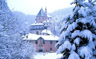a large building in the snow with snow covered trees at Appartamento Rosa in Coredo