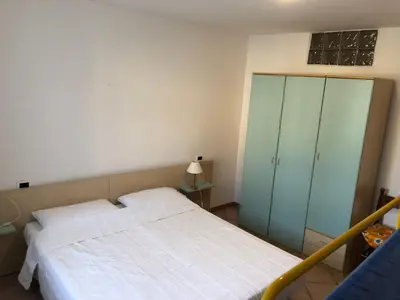 a bedroom with a bed and a green cabinet at Appartamento Rosa in Coredo